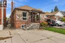 Exterior facade featuring mixed-material stone and brick masonry, covered front entryway with metal railings, and private concrete driveway - 81 East 23Rd Street, Hamilton, ON 