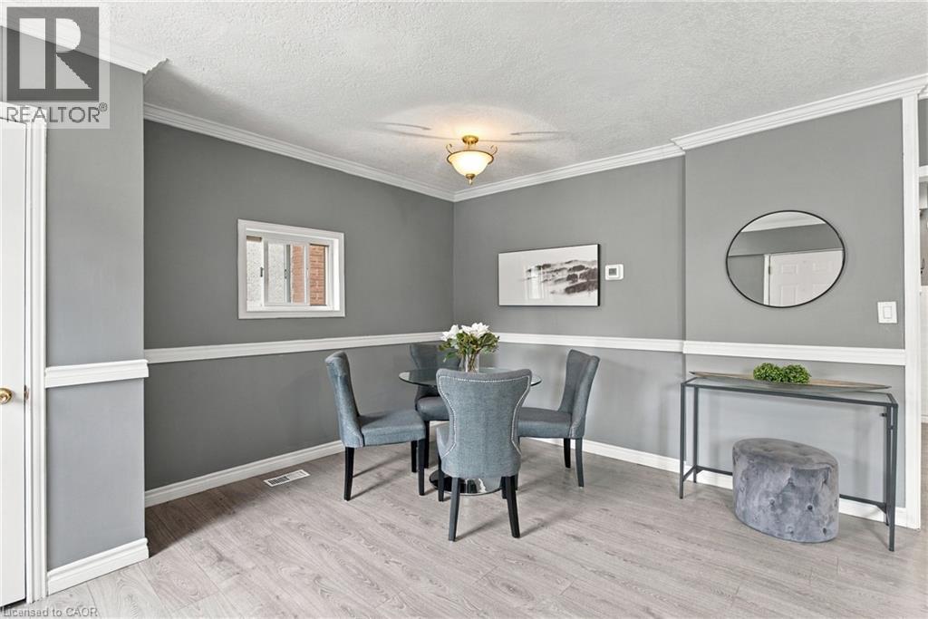 Neutral wall tones with white chair rail molding, ceiling-mounted light fixture, wood-finish flooring, and crown molding - 81 East 23Rd Street, Hamilton, ON