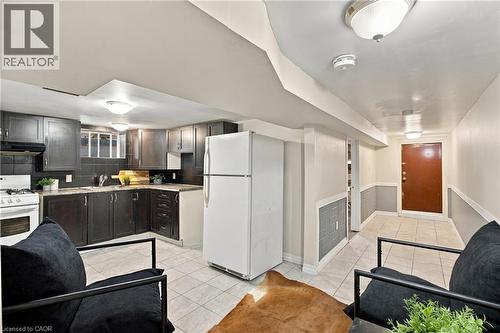 Kitchen featuring dark cabinetry, tile flooring, built-in range, and recessed ceiling lighting - 81 East 23Rd Street, Hamilton, ON 