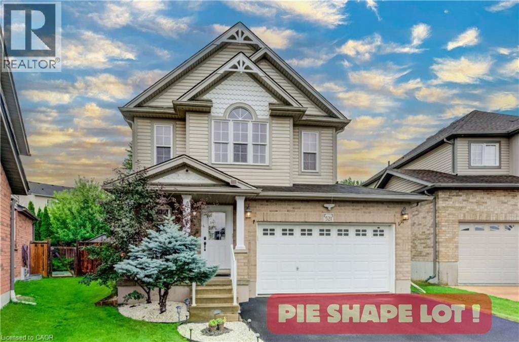 Two-story residence featuring a combination brick and vinyl siding exterior, an arched window detail, decorative gable accents, and an attached two-car garage - 521 Snowdrop Court, Kitchener, ON