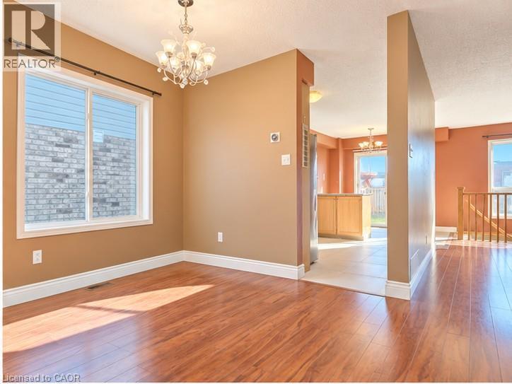 Wood-finish flooring, multi-light chandelier, large picture window, and neutral wall tones - 52 Isabella Street, Kitchener, ON