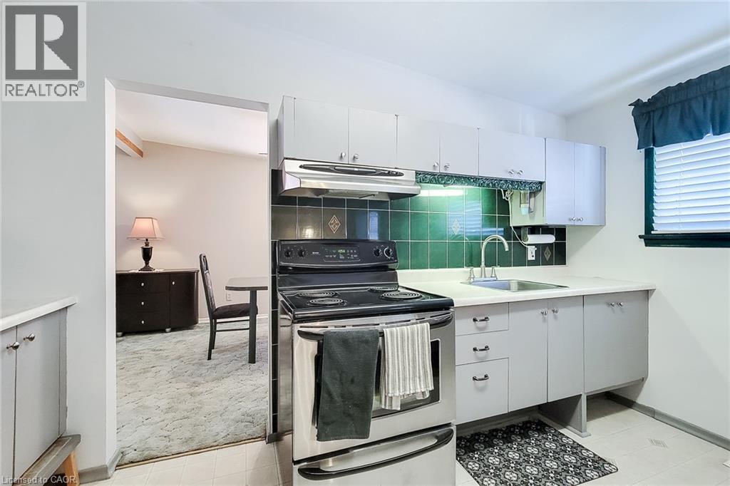 Traditional kitchen layout with generous counter space and convenient access to the dining area - 286 Mohawk Road W, Hamilton, ON