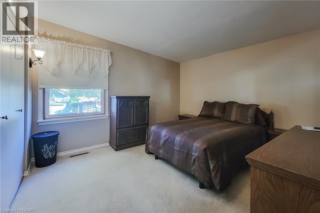 Another view of the primary bedroom featuring natural light and a practical layout - 286 Mohawk Road W, Hamilton, ON
