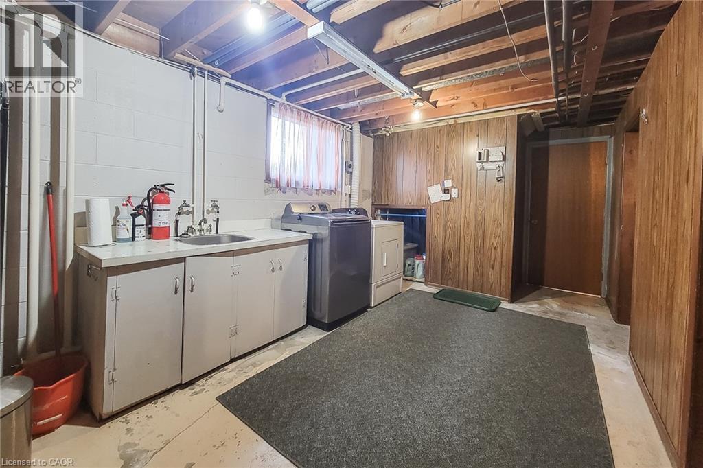 Dedicated lower-level laundry area with utility sink and additional storage space - 286 Mohawk Road W, Hamilton, ON