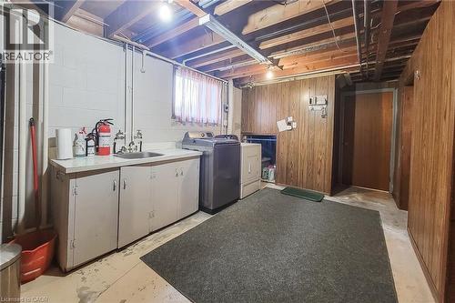Dedicated lower-level laundry area with utility sink and additional storage space - 286 Mohawk Road W, Hamilton, ON 