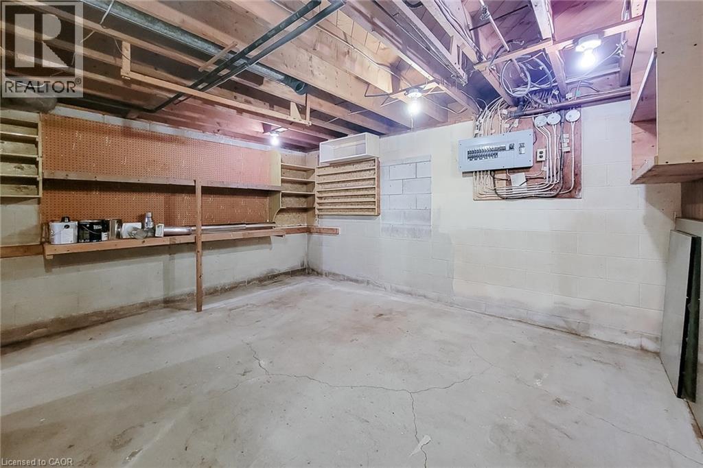 Unfinished workshop area with built-in shelving and plenty of room for tools and projects - 286 Mohawk Road W, Hamilton, ON