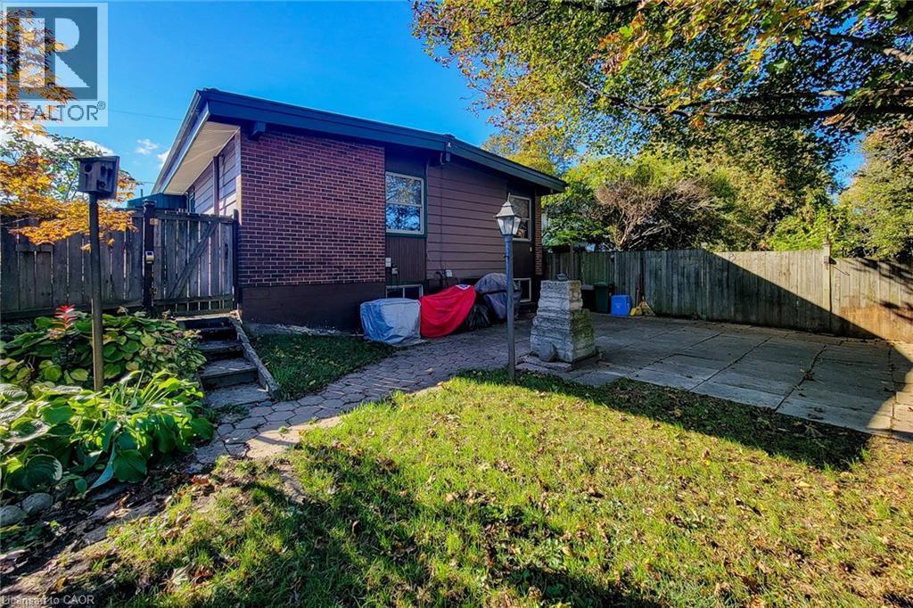Rear view of the bungalow with backyard access and space to enjoy the outdoors - 286 Mohawk Road W, Hamilton, ON