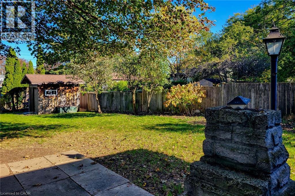Enjoy outdoor living with a spacious patio and mature trees overlooking the generous backyard - 286 Mohawk Road W, Hamilton, ON