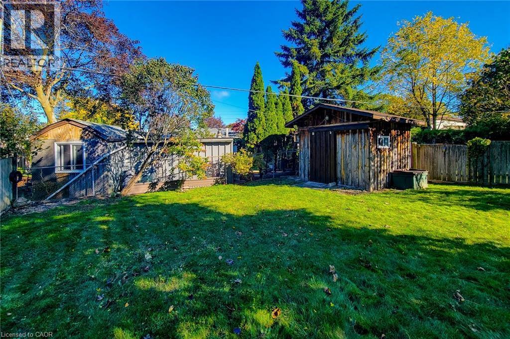 Deep backyard with mature landscaping and a handy garden shed for outdoor storage - 286 Mohawk Road W, Hamilton, ON