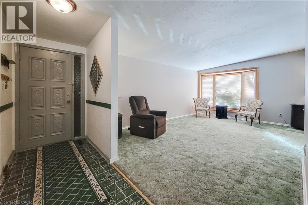 Inviting front entry opening into a spacious living room with a large picture window - 286 Mohawk Road W, Hamilton, ON