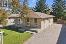 Single-story brick exterior with a low-slope roof, bay window, concrete front porch, and paved driveway - 11 Caledon Court, Cambridge, ON 