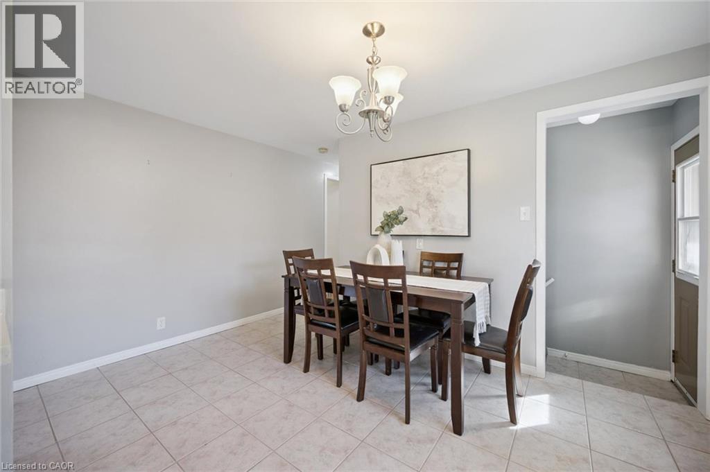 Neutral-toned walls paired with light-colored tile flooring and a multi-arm metallic chandelier - 11 Caledon Court, Cambridge, ON