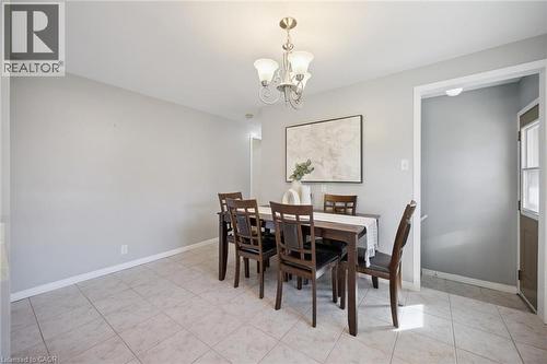 Neutral-toned walls paired with light-colored tile flooring and a multi-arm metallic chandelier - 11 Caledon Court, Cambridge, ON 