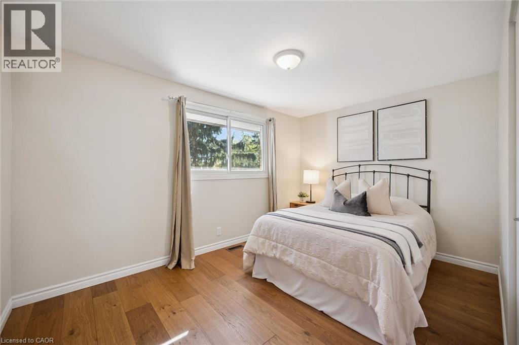 Neutral wall color, wood-finish flooring, and a large horizontal sliding window with natural light - 11 Caledon Court, Cambridge, ON
