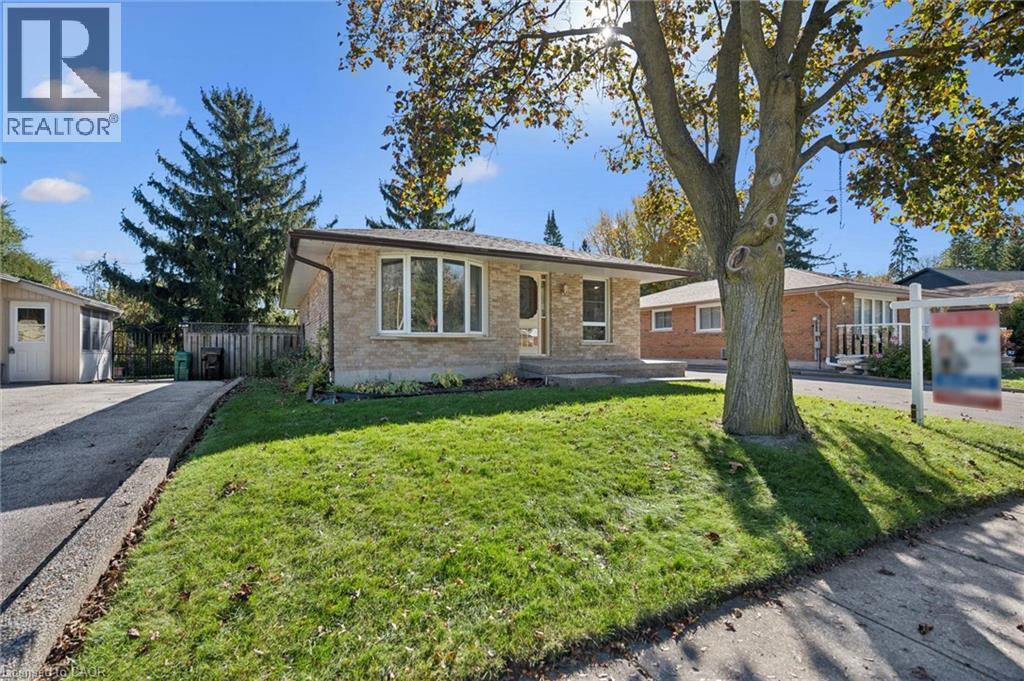 Single-story brick exterior featuring a front-facing bay window, paved private driveway, and mature landscaping - 11 Caledon Court, Cambridge, ON