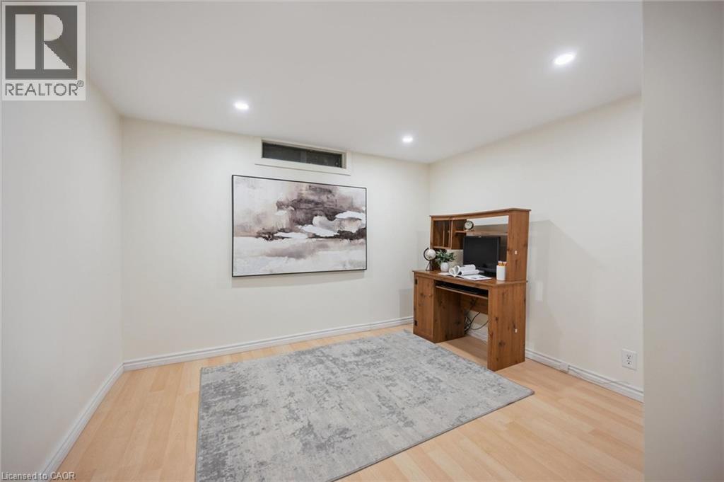 Neutral-toned room featuring recessed ceiling lighting, wood-finish flooring, and a rectangular transom window - 11 Caledon Court, Cambridge, ON