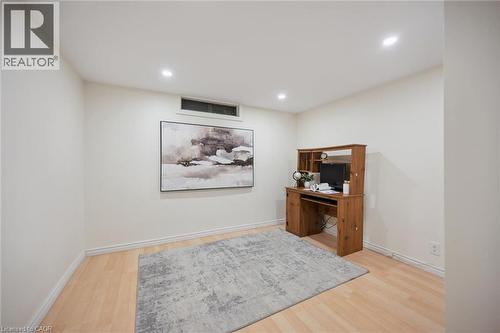 Neutral-toned room featuring recessed ceiling lighting, wood-finish flooring, and a rectangular transom window - 11 Caledon Court, Cambridge, ON 