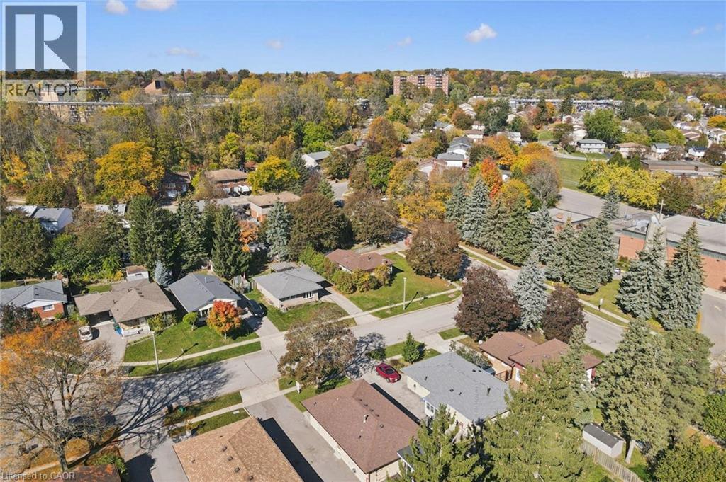 Aerial perspective of a suburban neighborhood featuring tree-lined streets, residential lots with paved driveways, and mature deciduous and coniferous trees - 11 Caledon Court, Cambridge, ON