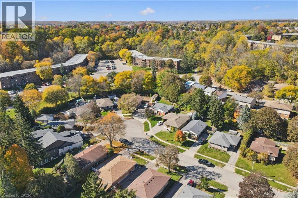 Aerial perspective of a residential street featuring suburban housing, asphalt roadways, concrete sidewalks, and mature tree-lined landscapes - 11 Caledon Court, Cambridge, ON