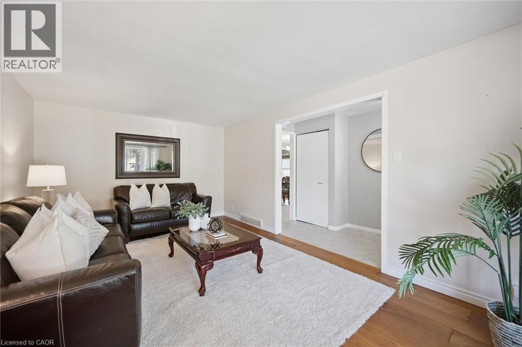 Neutral wall tones featuring wood-finish flooring and a white interior door - 11 Caledon Court, Cambridge, ON