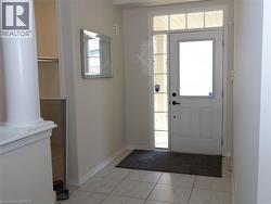 Entryway featuring tile flooring, a door with a glass insert, a sidelight window, a transom window, and a column detail -