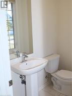 Pedestal sink with a single-handle faucet, wall-mounted mirror, and tile flooring -