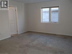 Neutral wall palette featuring carpeting, a multi-pane window, and a single-panel interior door -