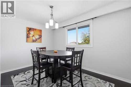 Neutral-toned walls, wood-finish flooring, sliding window, and a three-light brushed nickel fixture - 90 June Street, Hamilton, ON 
