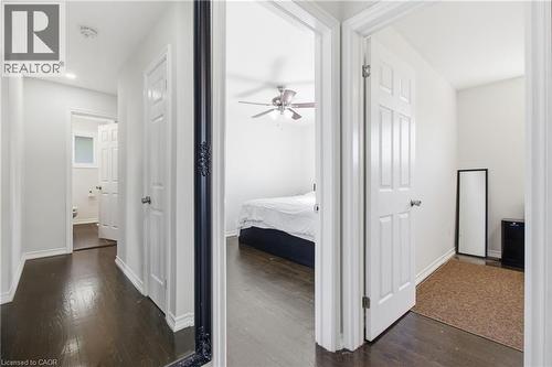 Interior hallway featuring dark wood-finish flooring, six-panel interior doors, and recessed ceiling lighting - 90 June Street, Hamilton, ON 