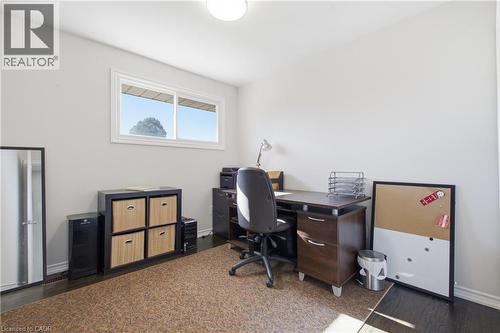Room featuring wood-finish flooring, neutral walls, and a horizontal sliding window - 90 June Street, Hamilton, ON 