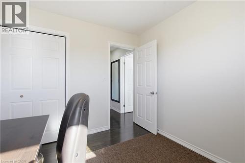 Neutral-toned interior featuring six-panel interior doors, a double-door reach-in closet, and dark wood-finish flooring - 90 June Street, Hamilton, ON 
