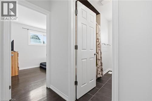 Six-panel interior door, wood-finish flooring, and dark tile flooring - 90 June Street, Hamilton, ON 