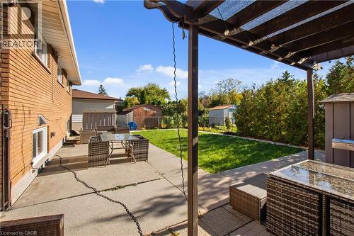 Backyard featuring a concrete patio, wood pergola, and fenced perimeter - 90 June Street, Hamilton, ON 