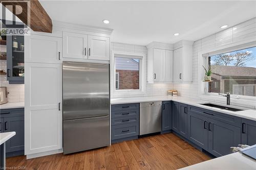 Stainless steel appliances, engineered hardwood flooring, white tiled backsplash, and recessed lighting. Fresh modern decor! - 10 Mulock Avenue, Hamilton, ON 