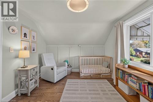 Oak hardwood flooring, panelled wall detailing featured in this cozy bedroom. - 10 Mulock Avenue, Hamilton, ON 