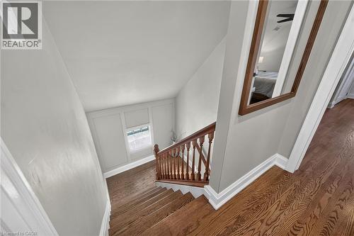 Staircase featuring hardwood  flooring and wall paneling. - 10 Mulock Avenue, Hamilton, ON 