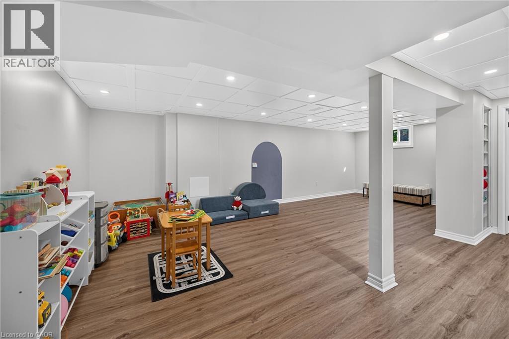 Finished lower level featuring vinyl plank flooring, recessed lighting and ample space to play. - 10 Mulock Avenue, Hamilton, ON