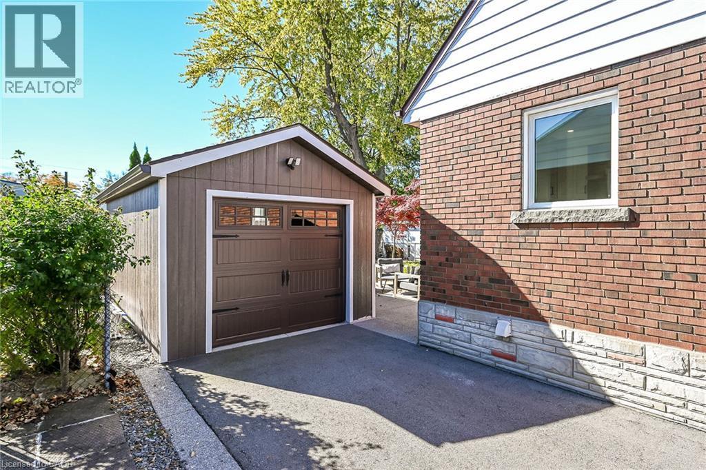 Detached single-car garage featuring a paneled door with windows, garage door opener and hydro. - 10 Mulock Avenue, Hamilton, ON