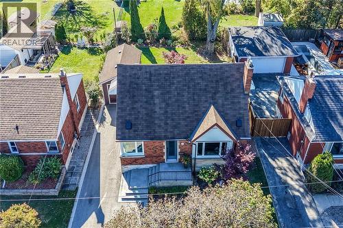 Brick exterior residence featuring an asphalt shingle roof, a detached garage, and a double driveway. - 10 Mulock Avenue, Hamilton, ON 
