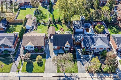 Aerial view of a residential property featuring a detached garage, asphalt driveway, manicured lawn, and mature trees - 10 Mulock Avenue, Hamilton, ON 