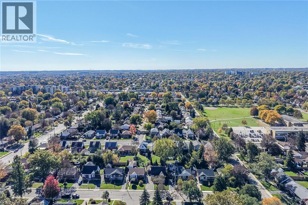 Aerial perspective of established suburban residential neighborhood featuring mature trees, grid-patterned streets, and proximity to expansive public green space, schools and shops. - 10 Mulock Avenue, Hamilton, ON
