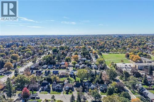 Aerial perspective of established suburban residential neighborhood featuring mature trees, grid-patterned streets, and proximity to expansive public green space, schools and shops. - 10 Mulock Avenue, Hamilton, ON 