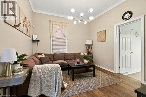 Spacious living area featuring warm-toned walls, crown molding, and updated flooring - 66 Beechwood Avenue, Hamilton, ON 
