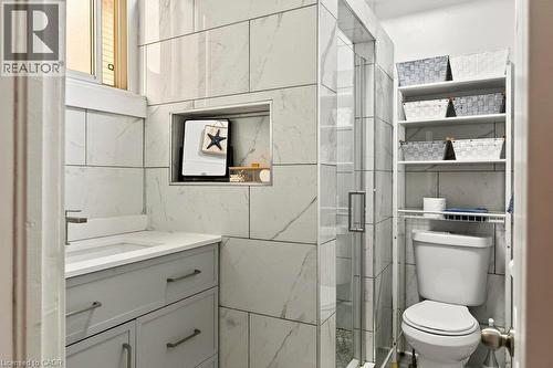 Newly renovated bathroom, featuring walk-in shower with glass door and modern white tiled surround - 66 Beechwood Avenue, Hamilton, ON 