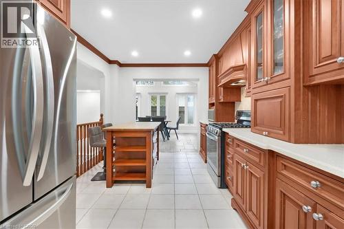 Kitchen featuring wood cabinetry, stainless steel appliances, a center island with a wood countertop, white tile flooring, and recessed lighting - 31 Berrisfield Crescent, Hamilton, ON 