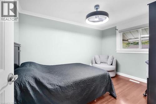 Hardwood flooring, recessed window, white crown molding, light-colored walls, and a modern ceiling fixture - 31 Berrisfield Crescent, Hamilton, ON 