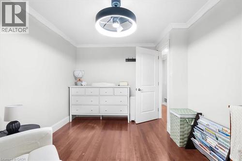 Hardwood flooring, crown molding, white walls, and a modern ceiling light fixture - 31 Berrisfield Crescent, Hamilton, ON 