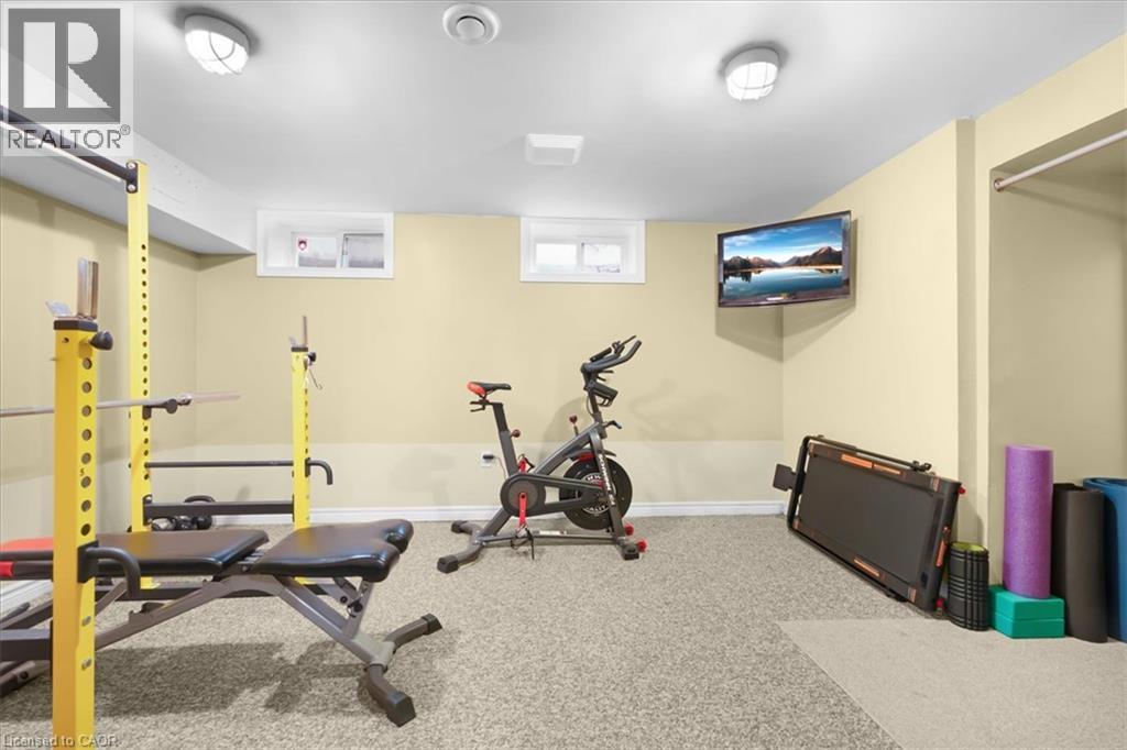 Recessed lighting fixtures illuminate the space, featuring neutral-toned walls and carpet flooring - 31 Berrisfield Crescent, Hamilton, ON