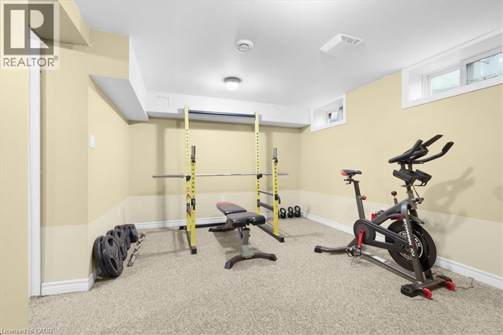 Carpeted room with painted walls, recessed lighting, and two white-trimmed windows - 31 Berrisfield Crescent, Hamilton, ON