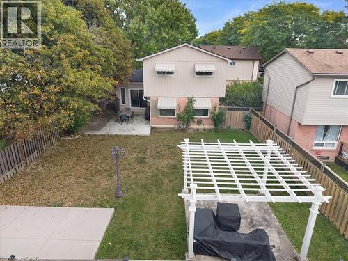 Expansive backyard featuring a pergola, concrete patio, and mature perimeter trees - 31 Berrisfield Crescent, Hamilton, ON 